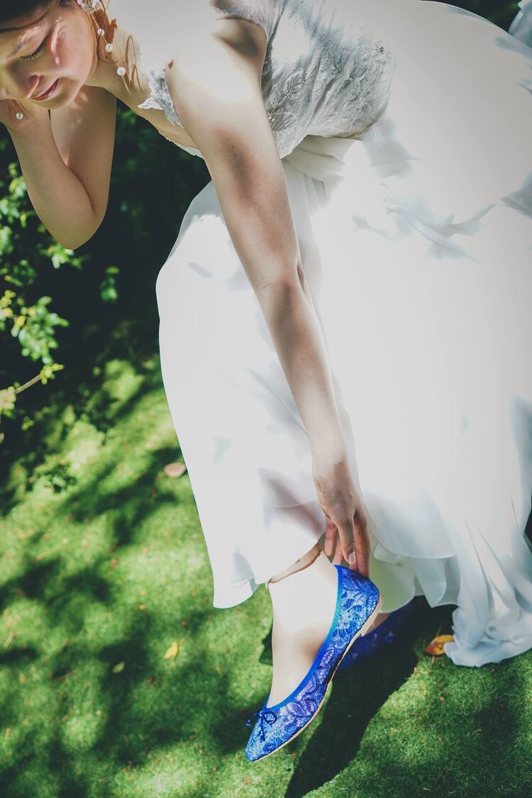 純白のドレスにブルーのレースが美しいポインテッドトゥバレエシューズを合わせた花嫁