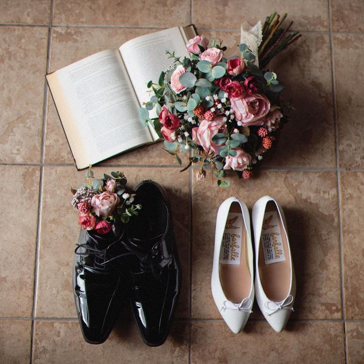 ブーケと新婦の白ののポインテッドトゥバレエシューズと新郎の黒のエナメル靴の前撮り写真