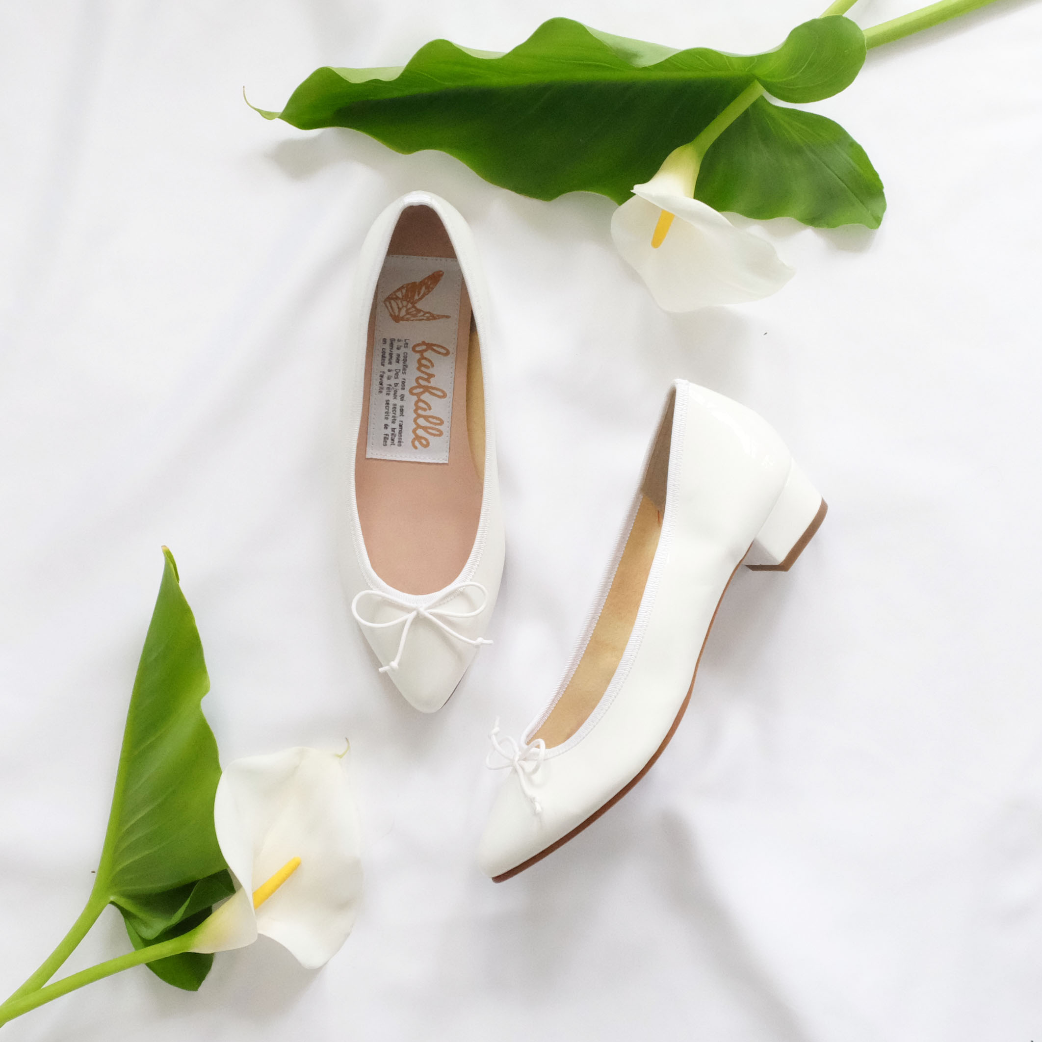 少し大人な雰囲気のあるエナメルの艶が上品な3㎝ヒールの白いポインテッドトゥバレエシューズ