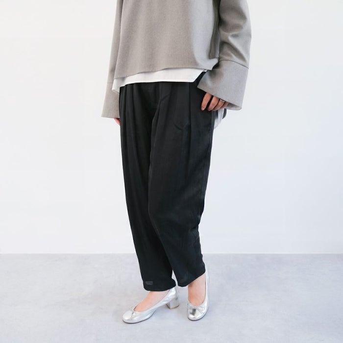 グレーのトップスに黒のスラックスをあわせたクールなスタイルにはシルバーのエルダで華やかさをプラス