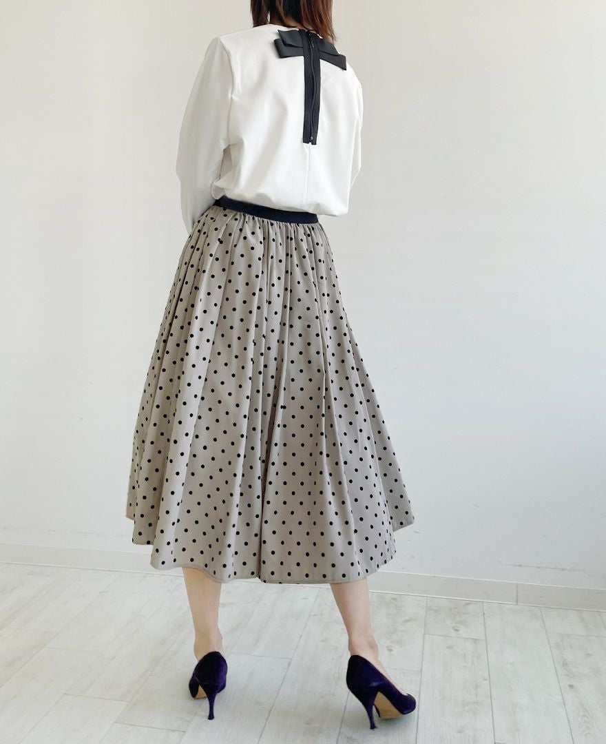 オフホワイトとフロッキードットスカートのグレージュを合わせて上品コーディネートに決まり後ろ姿が可愛いTRECODE（トレコード）のバックリボンプルオーバー