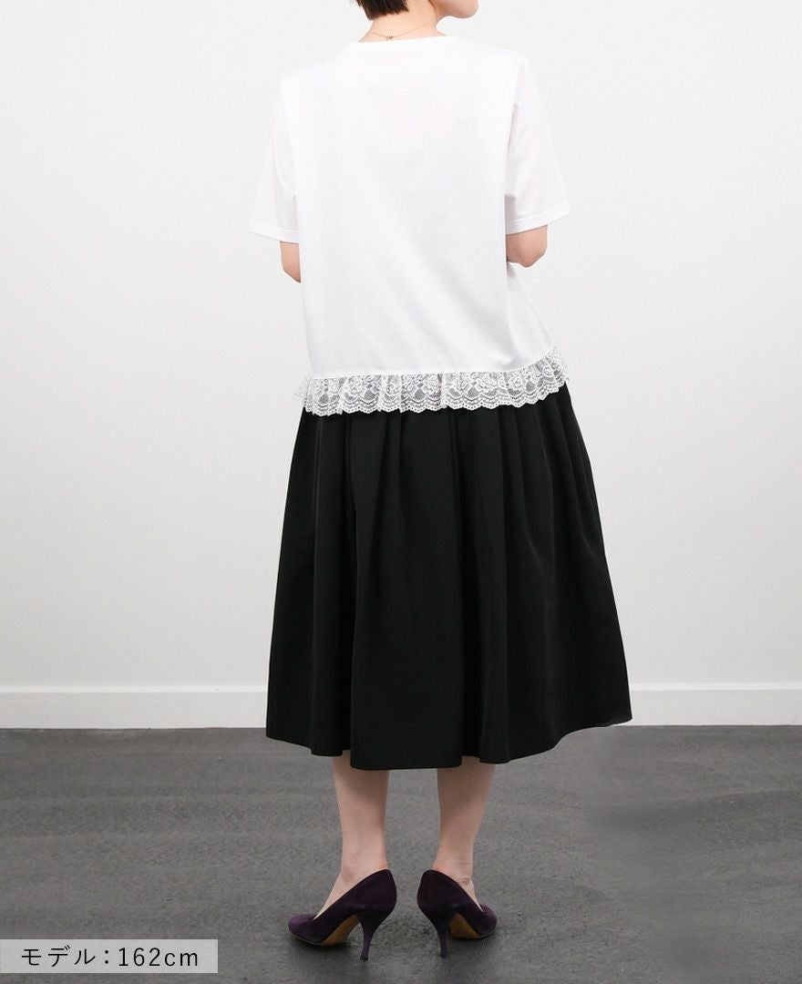 Hワイトの裾レースTシャツにブラックのミモレ丈スカートを合わせたコーディネート画像