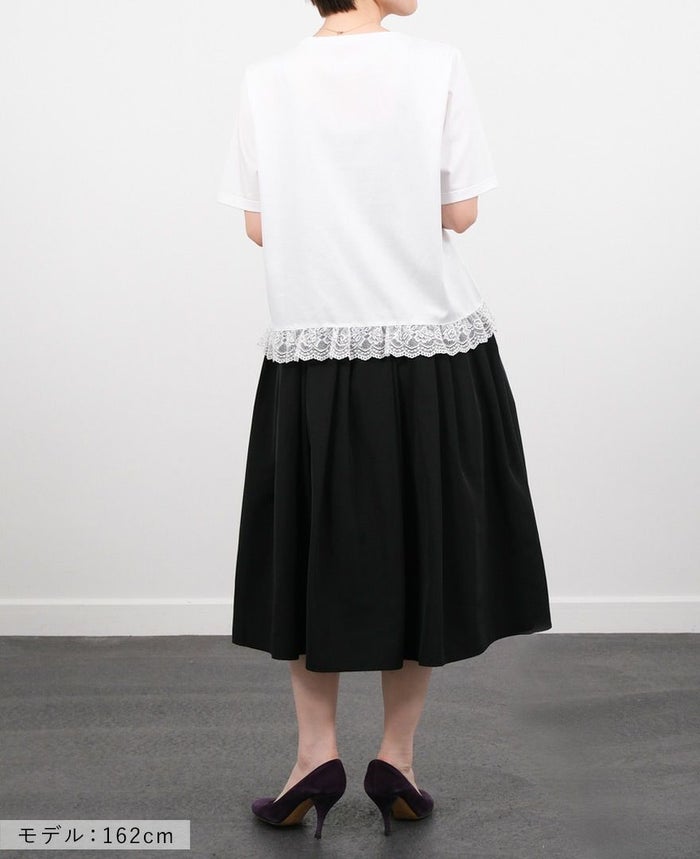 Hワイトの裾レースTシャツにブラックのミモレ丈スカートを合わせたコーディネート画像