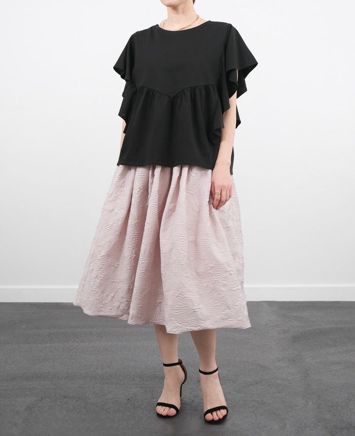 黒のフリルTシャツにペールピンクのスカートを合わせた大人可愛いコーデ