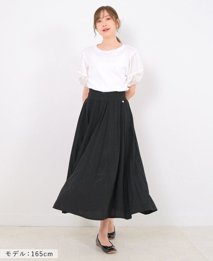 とろみのある素材がドレープを生みだす、着心地も快適なTRECODE（トレコード）のサマースカートのブラックに白のトップスと黒のシューズを合わせたおしゃれなスカートのワントーンコーデ