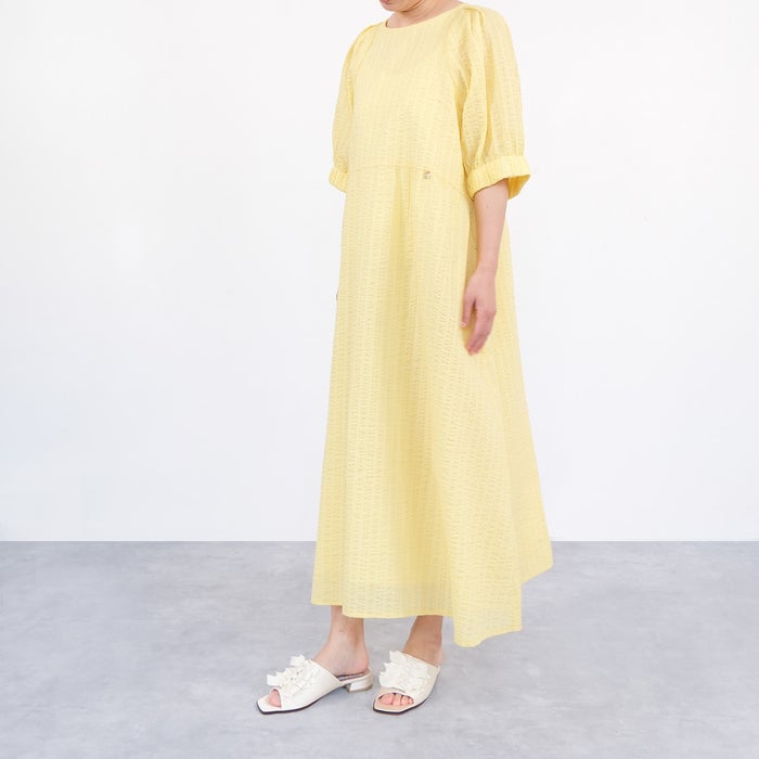 4連のサテンリボンが華やかなホワイトのミュールサンダルとイエローの軽やかなコットン素材のワンピースを合わせた夏らしい涼やかなコーディネート。